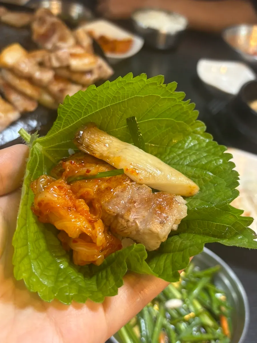 A piece of pork belly picked up with grilled onion