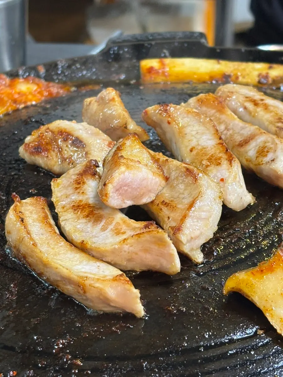 Pork jowl grilling on the pan