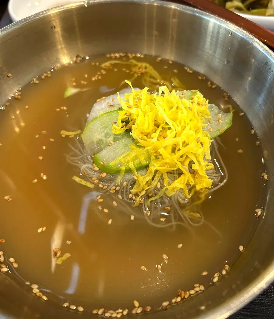 Bowl of naengmyeon topped with sliced egg