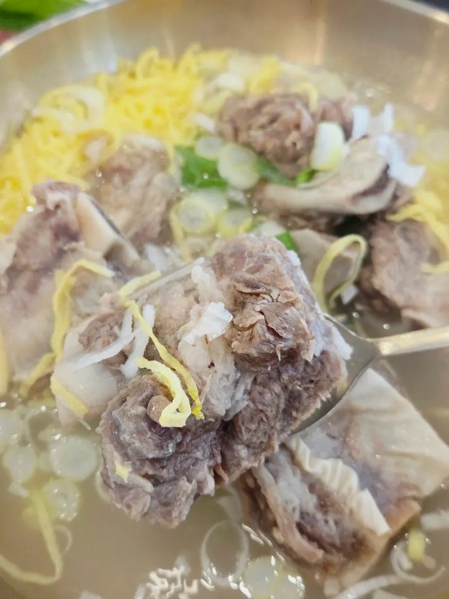 A bite of marinated galbi with sotbap wrapped together