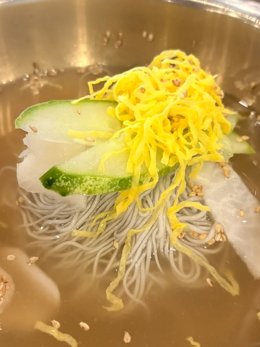 Water naengmyeon topped with cucumber, pear, and egg