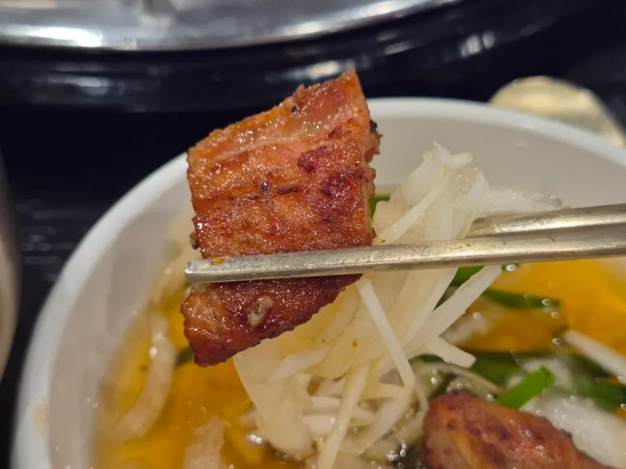 A piece of pork galbi topped with pickled onion