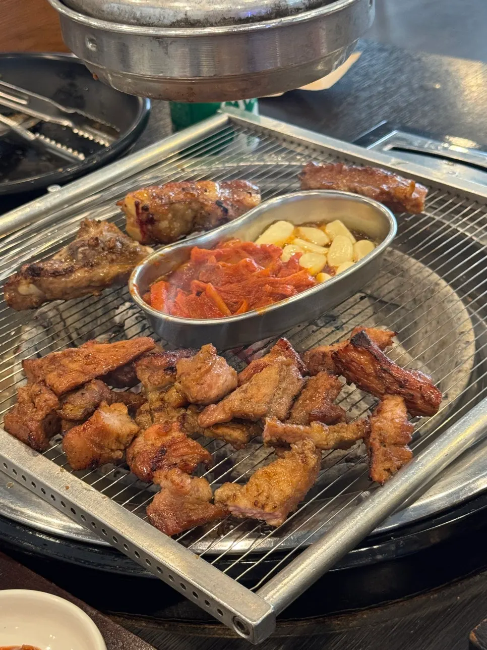 A piece of Manpo Galbi pork galbi held with tongs