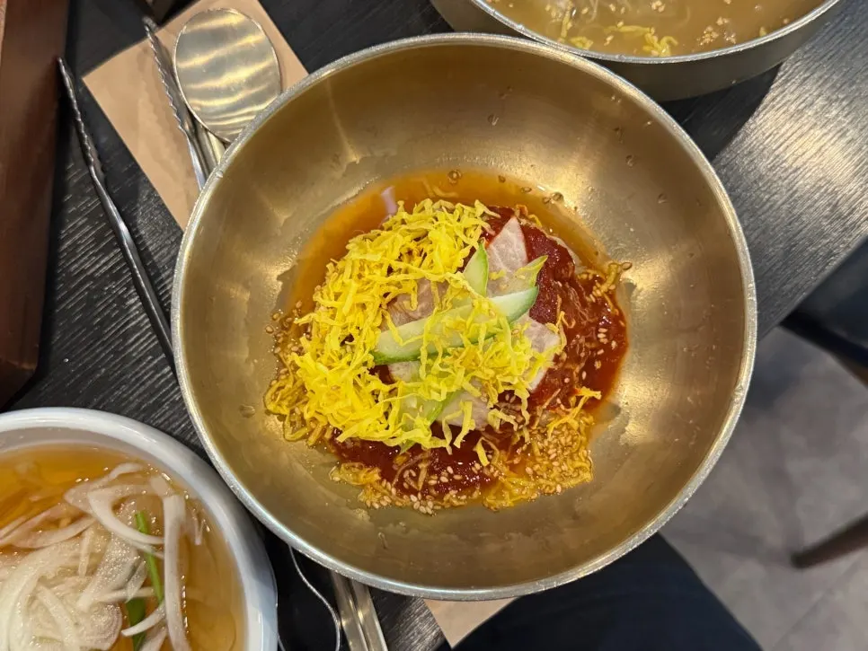 Water-based and spicy mixed naengmyeon placed together on the table