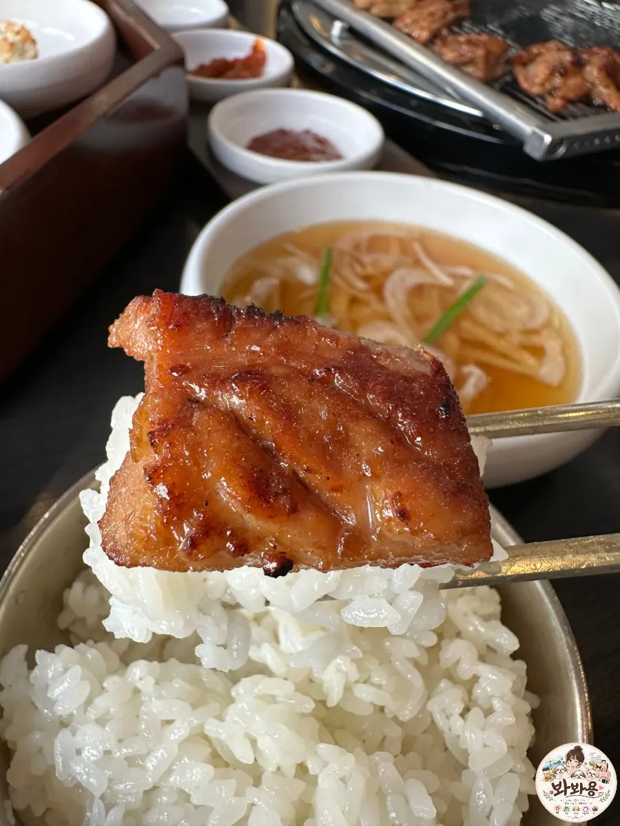 A piece of marinated galbi placed on a bowl of rice