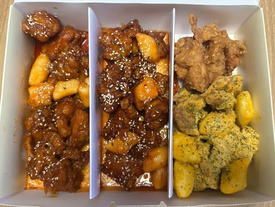 Freshly fried, warm dakgangjeong being packaged