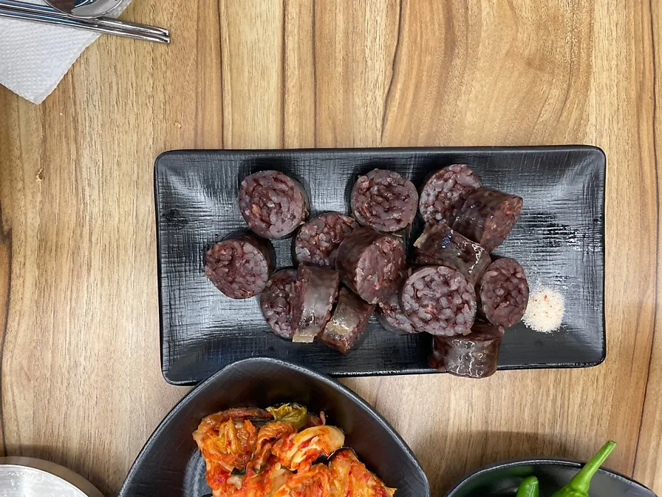 밥에 고기를 올린 돼지국밥 한 숟가락