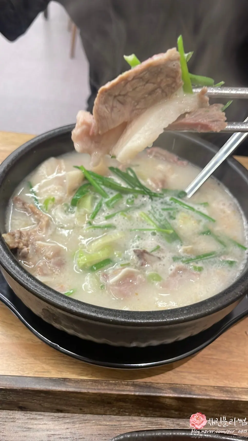 Pork gukbap topped with chives and green onion