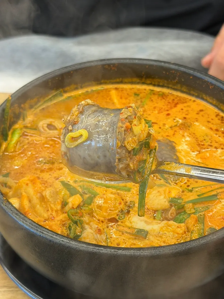 Lifting up a piece of bone soup meat