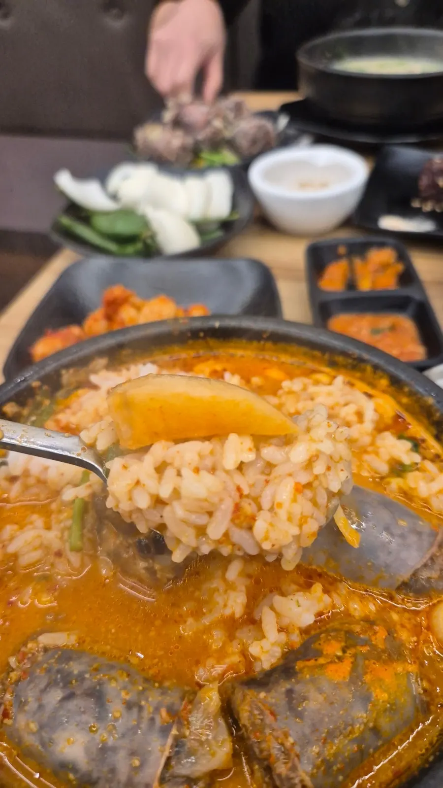 A spoonful of sundaeguk with rice mixed in