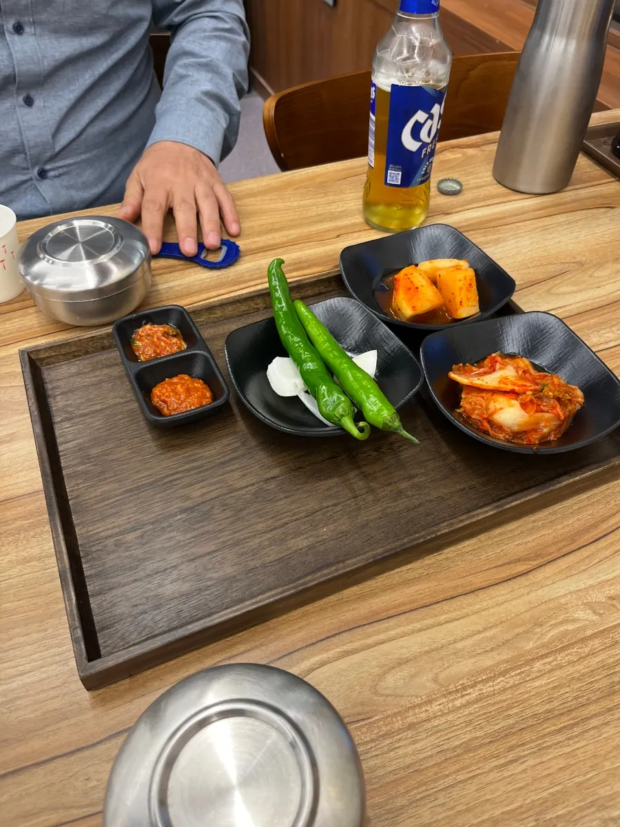 Basic side dishes served on a wooden tray with salted shrimp and ssamjang