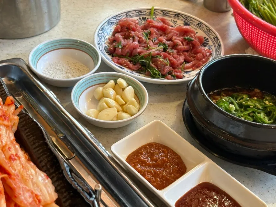Basic banchan including beef tartare and kimchi pancake