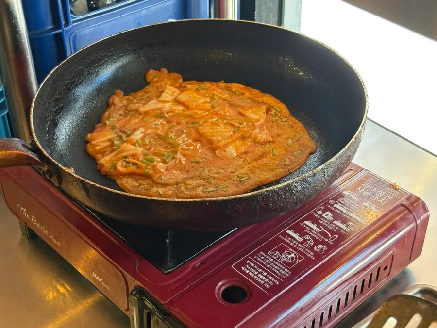 Grilling minari kimchi pancake at the self-serve station