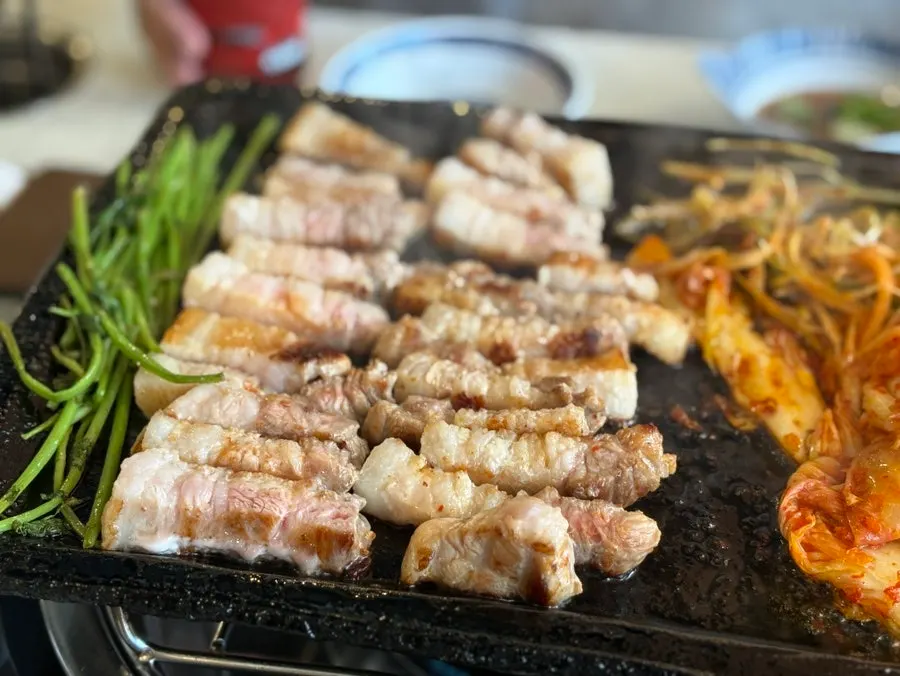Pork belly served with minari and kimchi