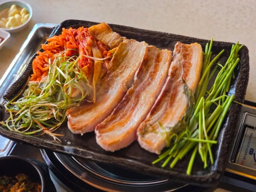 Pork belly and shredded scallion salad laid out by staff