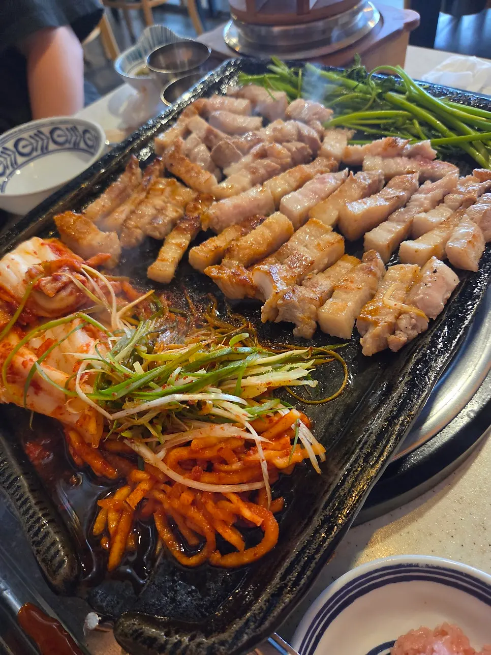 불판에 올린 삼겹살과 미나리, 김치