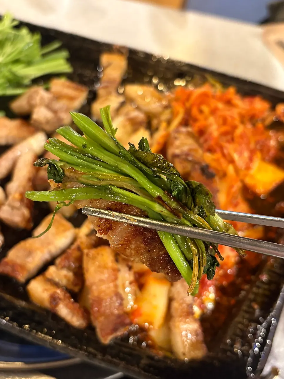 A wrap of pork belly topped with minari