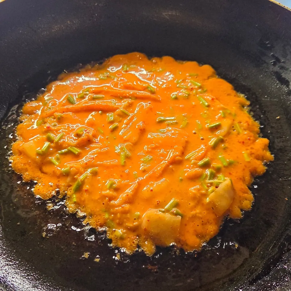 Frying minari kimchi pancake in a pan at the self-bar