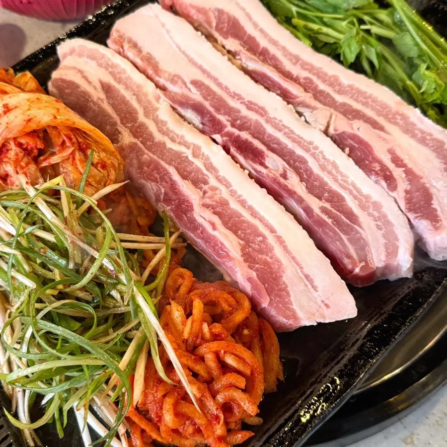 Pork belly on the grill with minari and kimchi