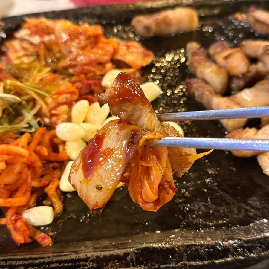 A bite of pork belly with grilled kimchi