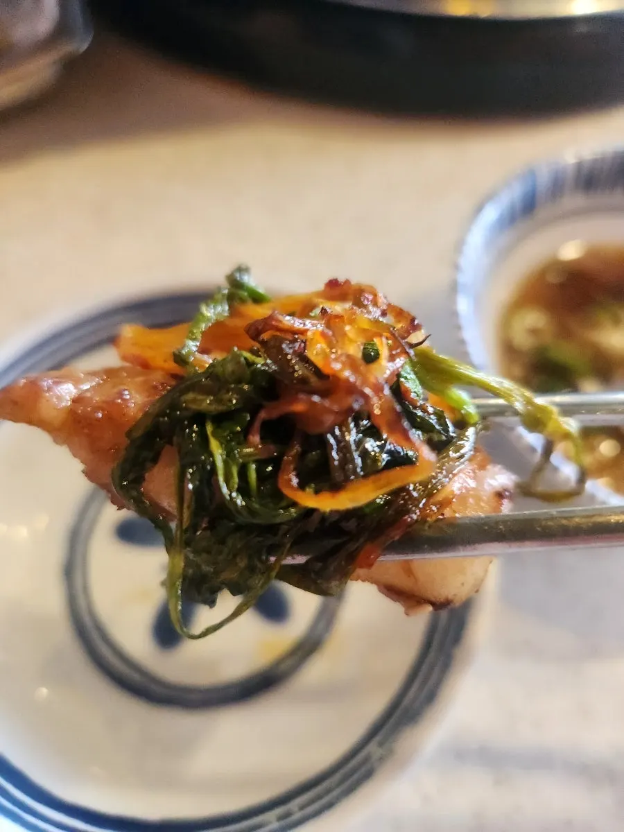 A piece of pork belly paired with minari