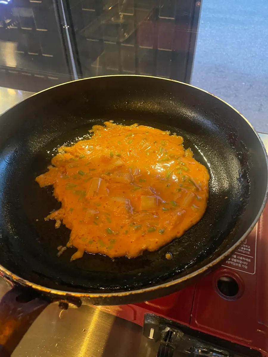 Minari-kimchi pancake browning in the pan