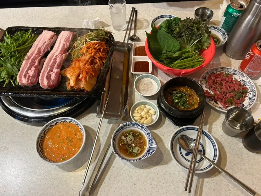 불판 위에서 구워지는 삼겹살과 무생채 파채