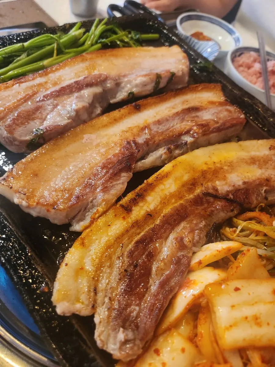 Pork belly served with kimchi and minari