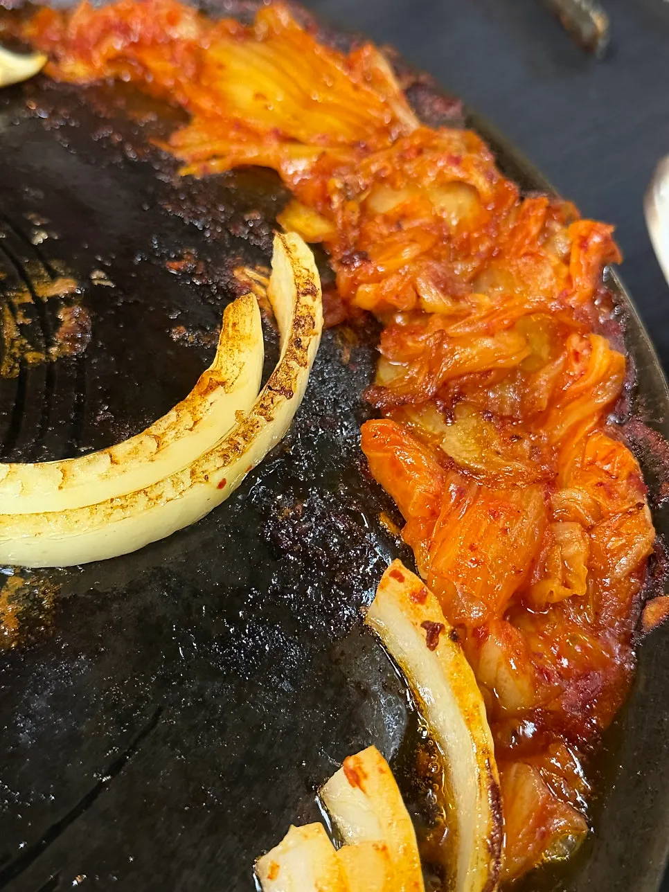 Kimchi cooking on one side of the cauldron lid