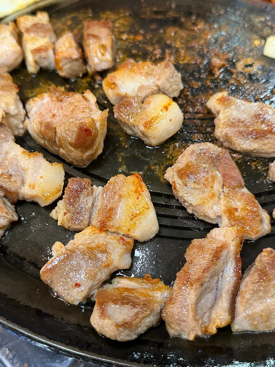 The cauldron lid full of grilled meat and kimchi