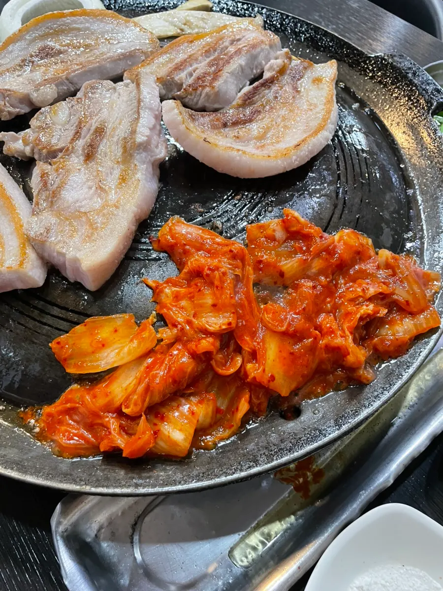 Pork belly and kimchi grilling on the cauldron-lid grill