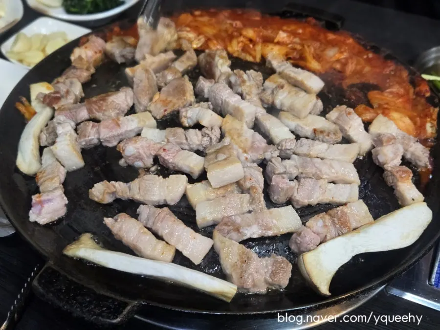 トングで肉をひっくり返す様子