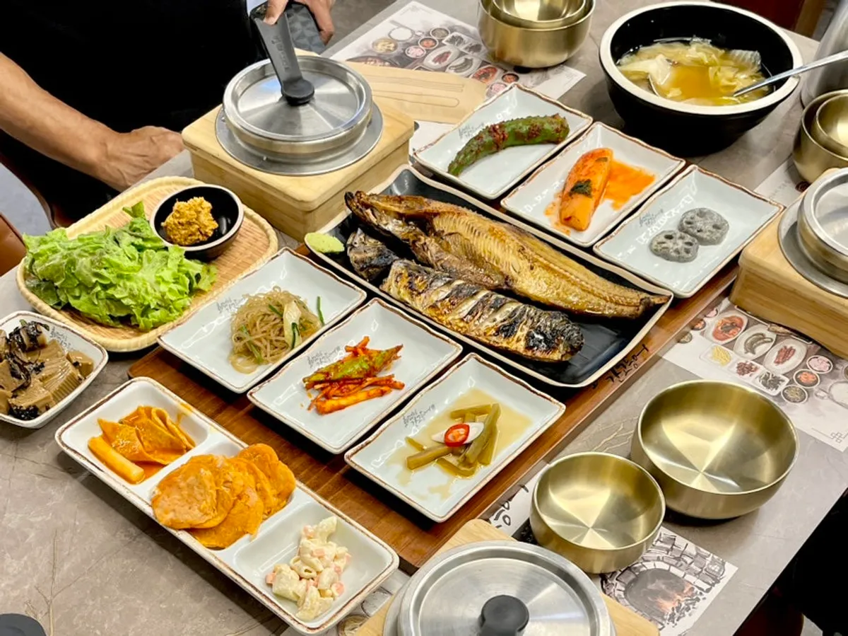 A full spread of grilled fish and side dishes with the rice-pot set