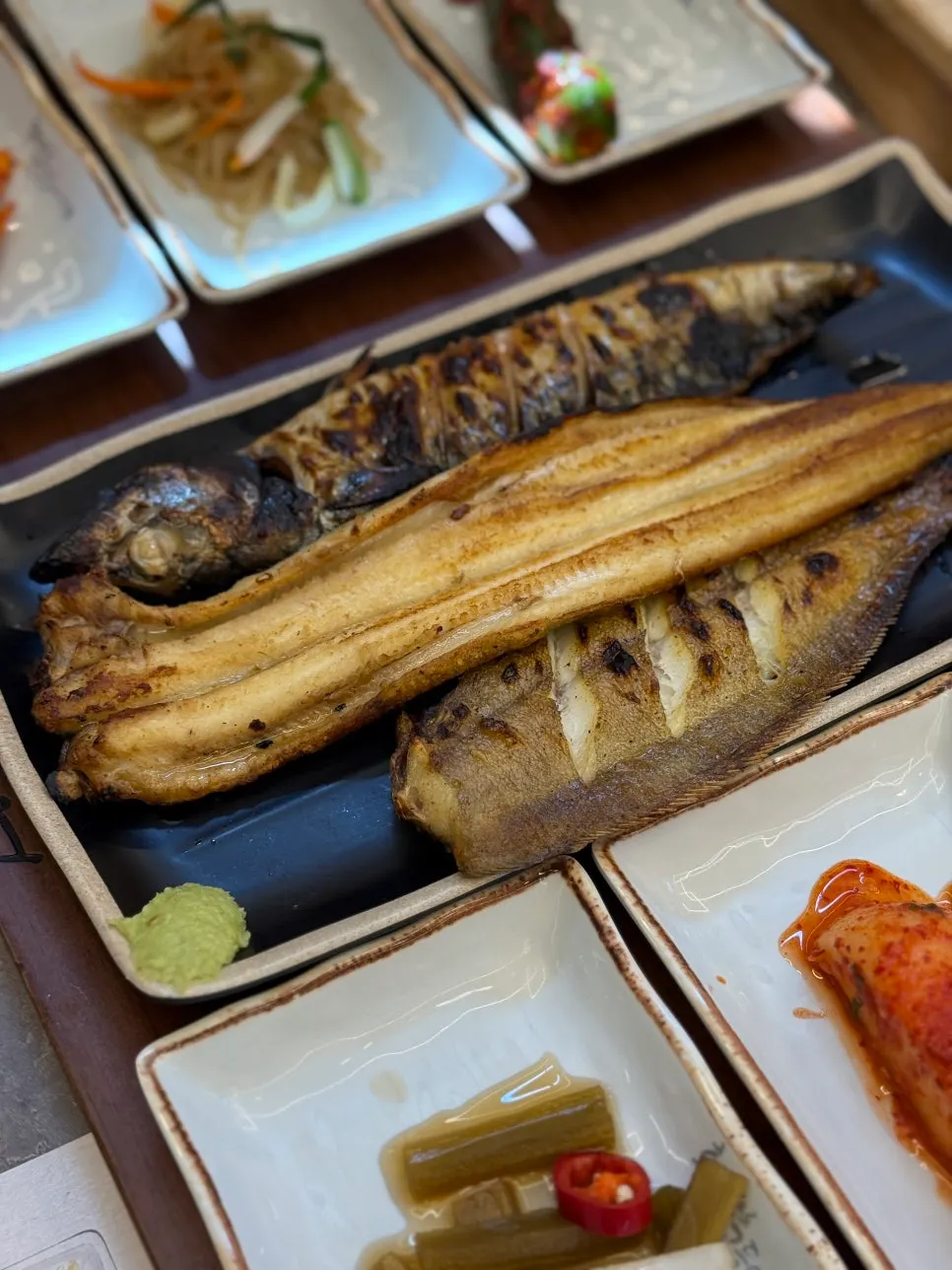 炭火の香りが染み込んだ化덕焼き魚の皿