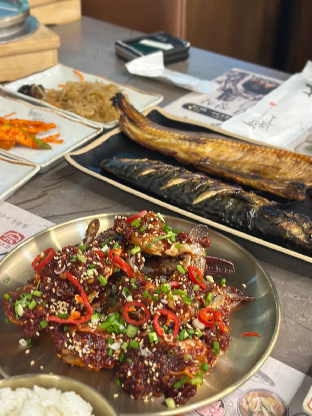 A full table spread with grilled fish and seasoned crab