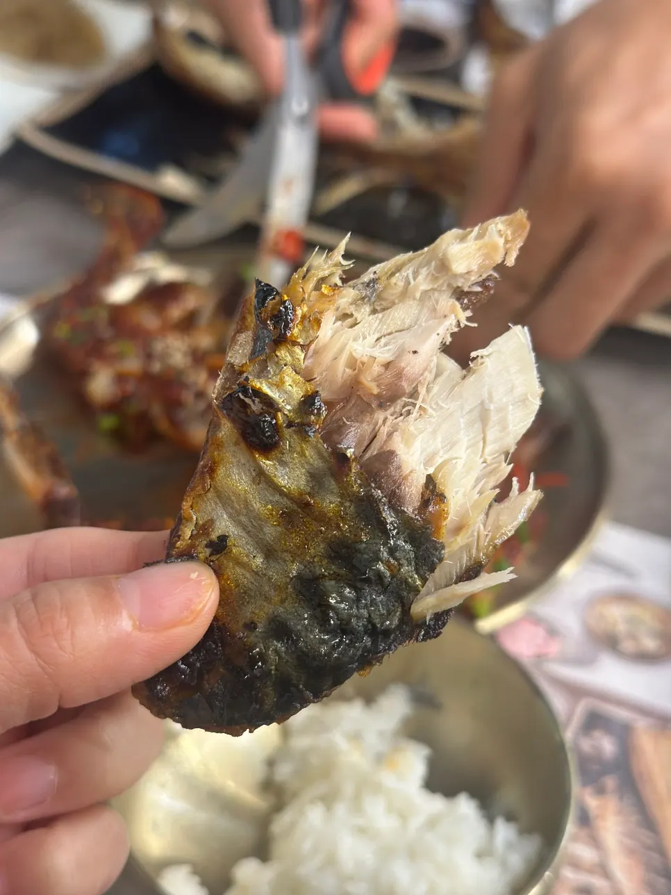 Rice pot with rice served out, alongside grilled fish