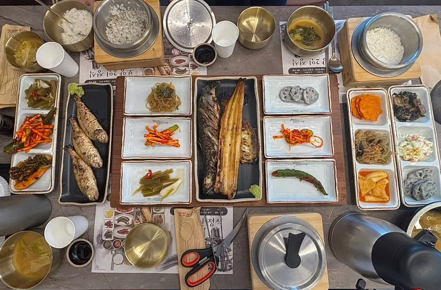 A full setting of grilled fish and side dishes