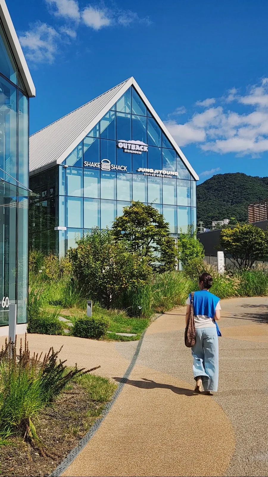Hill path with the glass-walled building in view