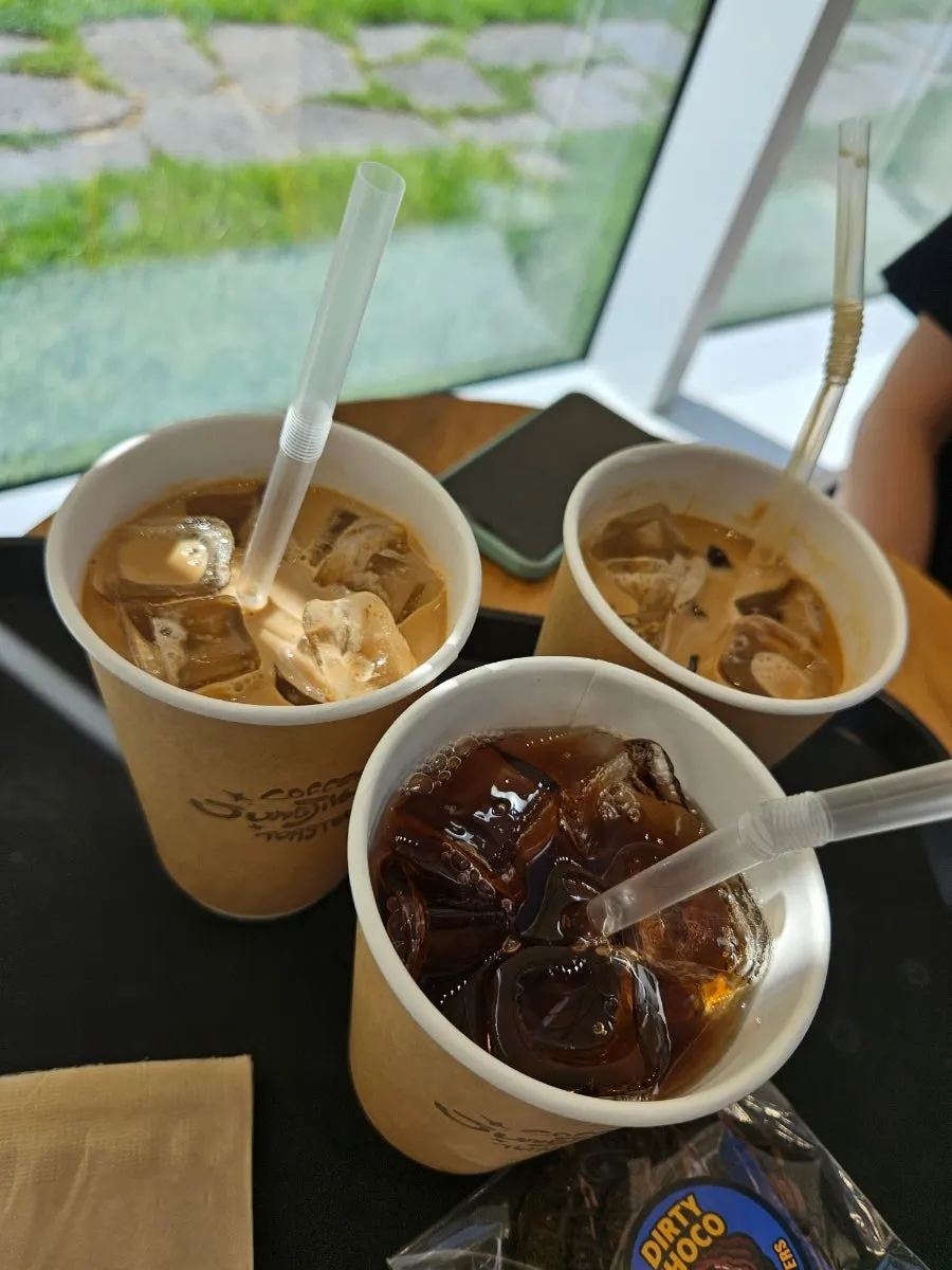 Iced café latte and peach iced tea served in paper cups