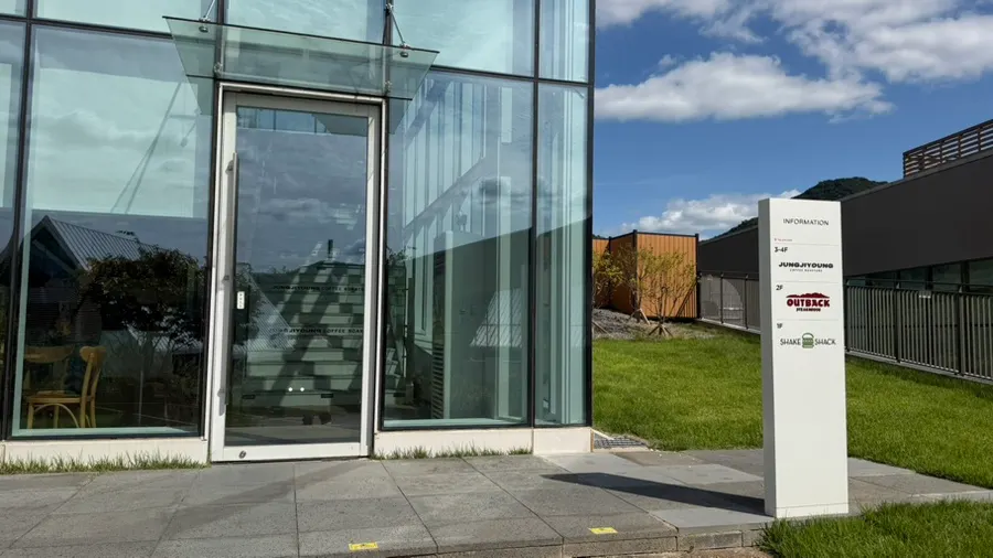 Outlet glass building reflecting a clear blue sky