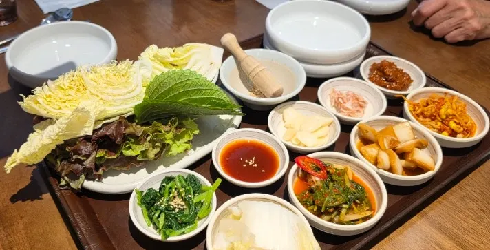 밑반찬과 쌈채소가 차려진 울동보쌈 보쌈 한상
