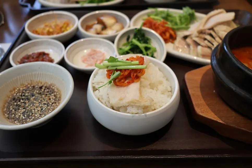 A bossam wrap topped with minari and radish salad