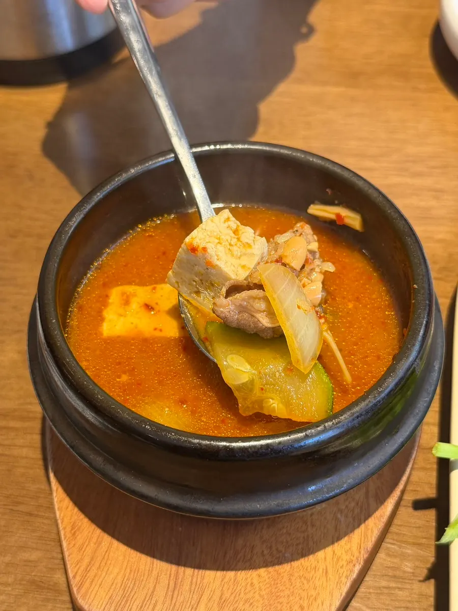 Two cuts of bossam pork with radish kimchi and minari