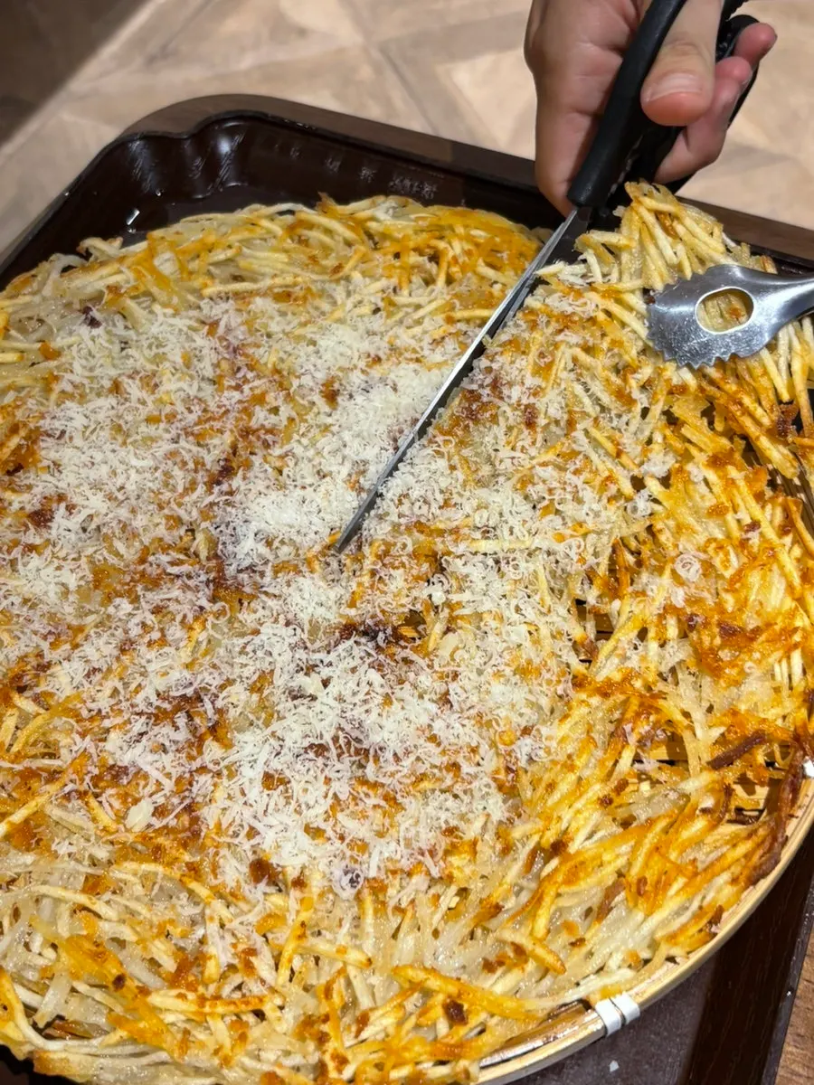 Julienned potato pancake topped with grated cheese