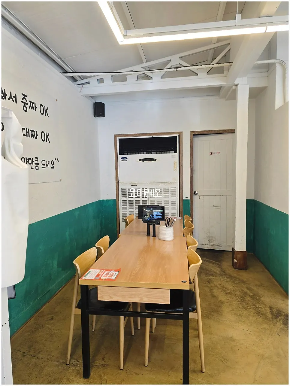 딥그린 벽면과 원목 테이블 좌석