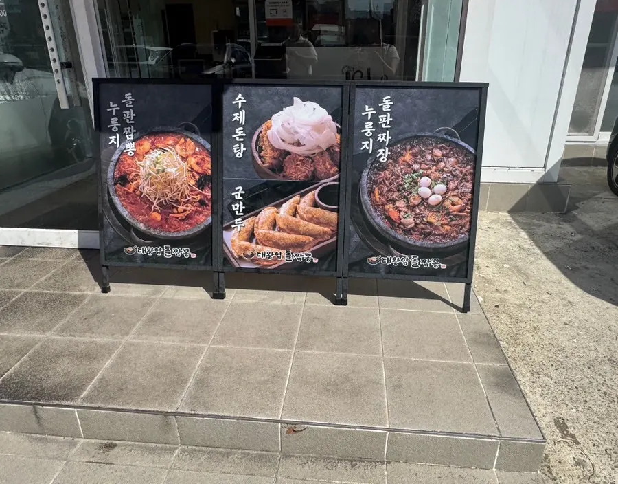 Photos of stone jjamppong and jjajang on the restaurant's exterior wall