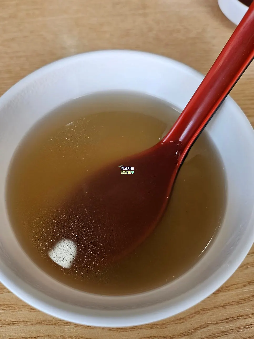 Warm beef broth served in a cup