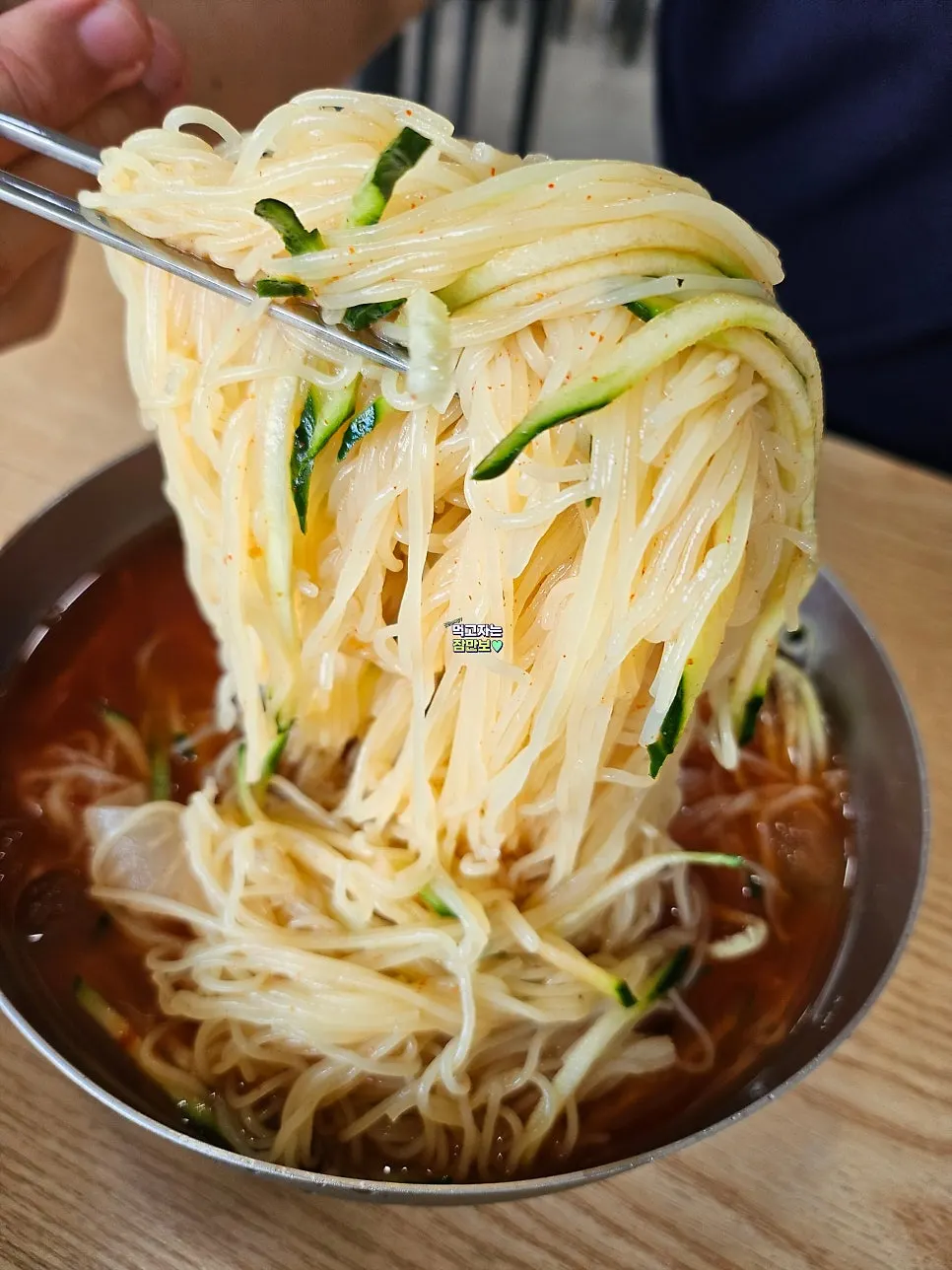 Chopsticks lifting water milmyeon mixed with dadaegi sauce