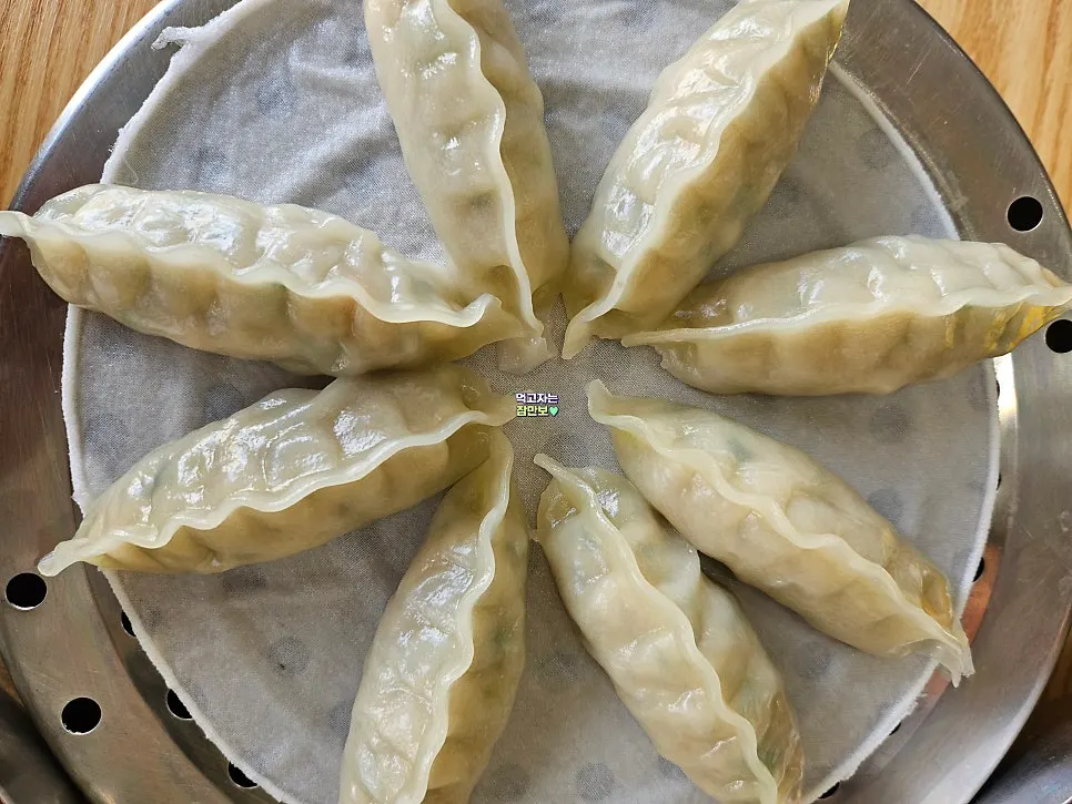 A bite of bibim milmyeon noodles placed on top of egg
