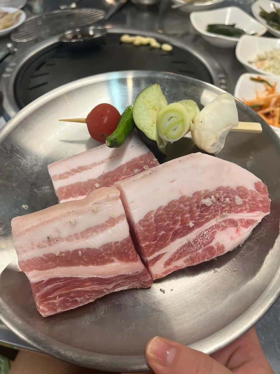 Two servings of raw black pork belly on a plate